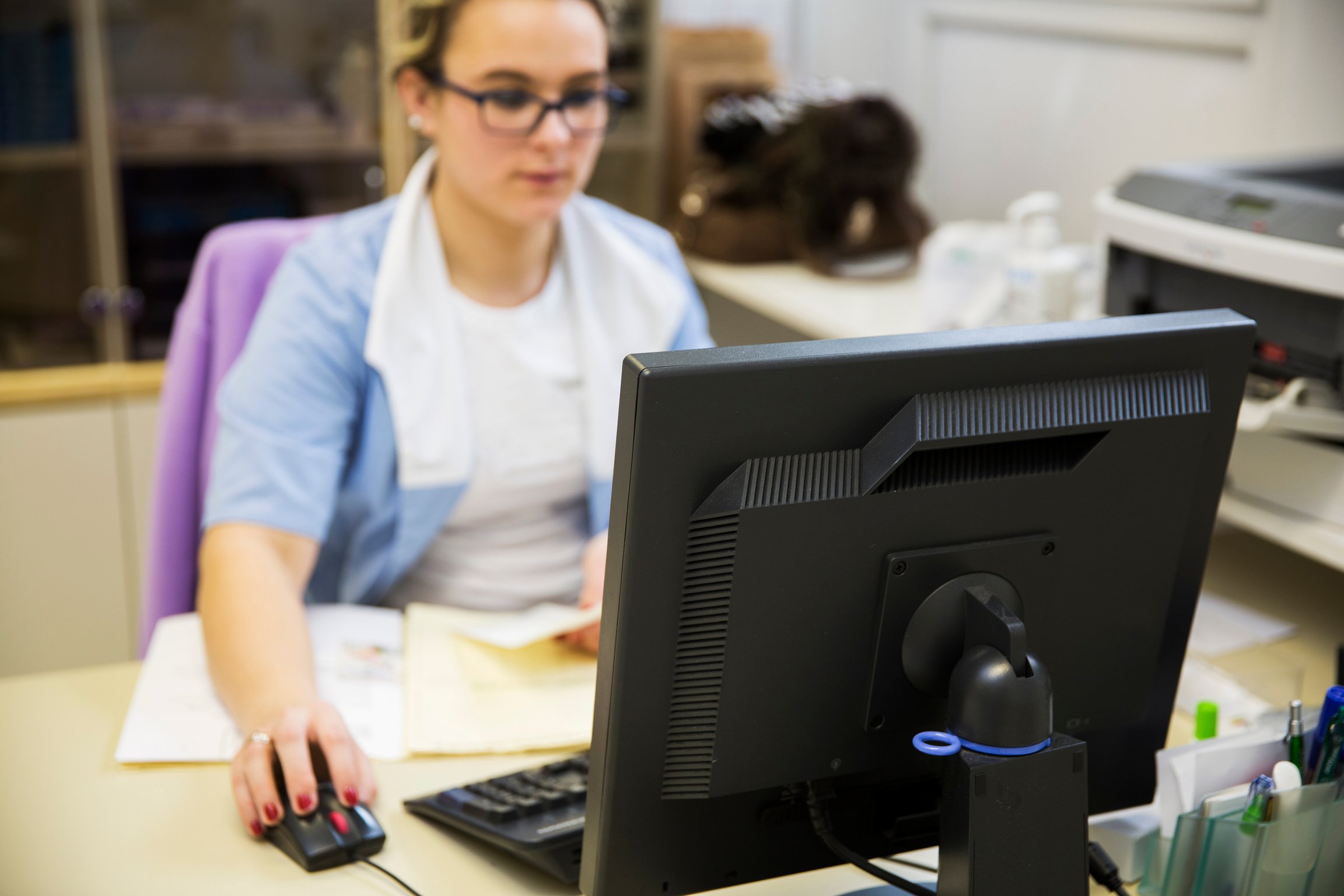 Nurse in her office,working with computer,daily paperwork